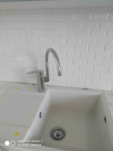 Установлены шкафы, смонтирована столешница, закреплена мойка и смеситель, подключены коммуникации, выполнена облицовка фартука плиткой. Работа завершена.