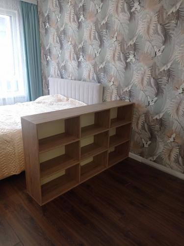 Собран новый книжный стеллаж из деревянных панелей, установлен в спальне. Конструкция устойчива, полки ровные, обеспечивают удобное хранение вещей. Завершено аккуратно и качественно.