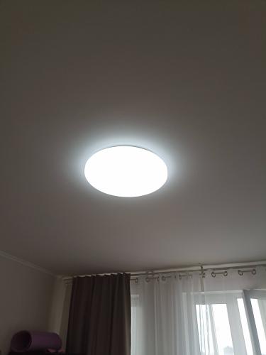 Закреплен круглый светильник на потолке, подключен к электросети, обеспечивая равномерное освещение комнаты. Установлены крепления, проверена надежность соединений и функциональность.