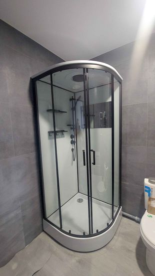 Установлена современная душевая конструкция с низким основанием. Закреплены стеклянные панели, смонтированы дверцы, подключены водопроводные элементы, обеспечена герметичность соединений.