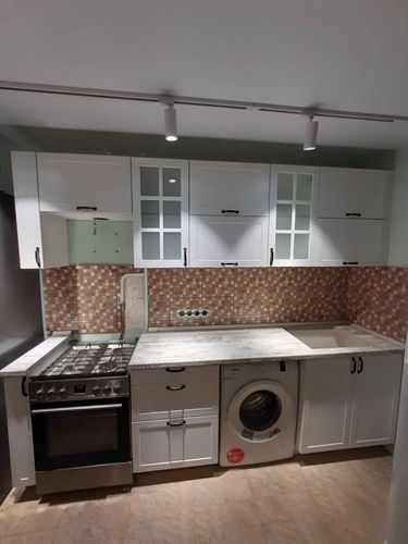 Установлены шкафы, закреплены ручки, смонтирована столешница, подключена плита, встроена мойка, размещена стиральная машина, выполнен монтаж фартука, установлены светильники.