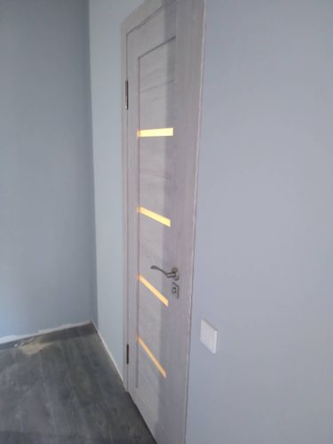 Выполнена установка новой деревянной двери: закреплены петли, врезан замок, установлена ручка, отрегулировано полотно, обеспечена плавность закрытия, произведена отделка коробки.