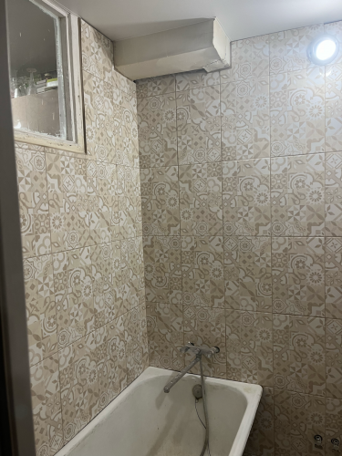 Завершена облицовка стен кафелем с узором, обеспечивающая водостойкость и эстетичный вид. Установлена сантехника, обеспечена герметизация швов, что создает комфорт и долговечность.