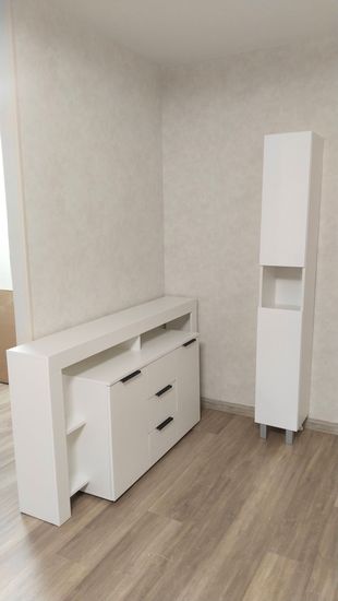 Собран белый комод с тремя ящиками и двумя дверцами, установлен на ровный пол, проверена устойчивость, закреплены ручки, выровнены фасады, обеспечена функциональность и эстетичность.