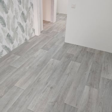 Покрытие ровно уложено на подготовленное основание, стыки аккуратно соединены, поверхность гладкая и без дефектов, создавая единый стильный вид в помещении.