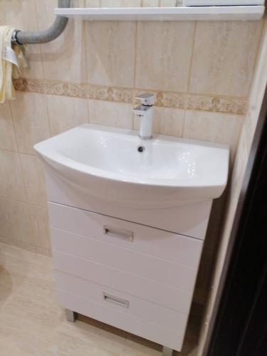 Изображение ванной комнаты с установленным зеркальным шкафом над раковиной. Шкаф надежно закреплен на стене, обеспечивая удобное хранение и доступ к предметам личной гигиены.