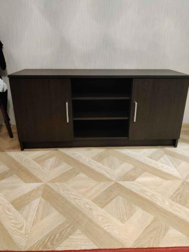 Собрана новая мебель: установлены боковые панели, закреплены дверцы, прикреплены полки, ручки. Все элементы соединены, конструкция устойчива, готова к использованию.