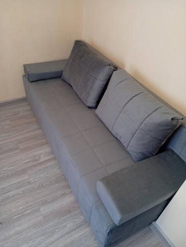 Собран диван: установлены подлокотники, закреплены спинки, уложены подушки, проверена устойчивость конструкции, выровнены детали, завершена сборка, обеспечена функциональность.