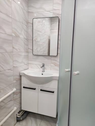 Установлены трубы для холодной и горячей воды, подключен умывальник, смонтирован смеситель, выполнена облицовка стен плиткой, проведена герметизация стыков, обеспечена функциональность системы.