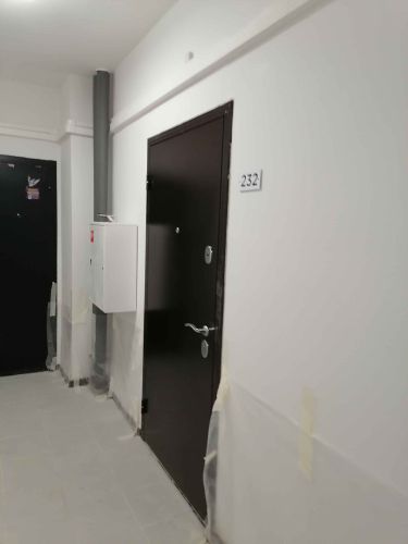 Изображение демонстрирует завершённый монтаж входной конструкции. Установлена новая дверь, произведена регулировка петель, обеспечена герметичность, выполнена отделка откосов, закреплены ручки и замки.