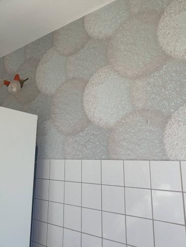 Стены оклеены обоями с узором в виде крупных кружков, создающими стильный и современный вид. Работа выполнена аккуратно, без видимых стыков и дефектов.