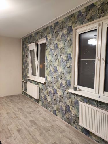 На стенах аккуратно наклеены фотообои с растительным узором, создавая уютную атмосферу. Поверхность ровная, без видимых стыков, что придаёт интерьеру завершённый вид.