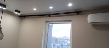 На стене закреплён карниз над окном, обеспечивая прочное крепление для штор. Установлены крепежи, выровнена конструкция, обеспечена надёжность и эстетичность.