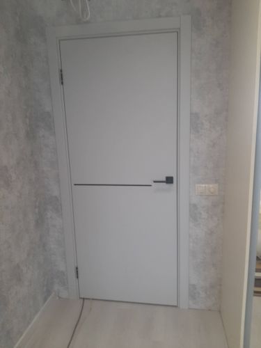 Установлена новая дверь: закреплены петли, врезан замок, отрегулирована створка, обеспечен плавный ход. Оформлен проем, добавлены наличники, завершена отделка.