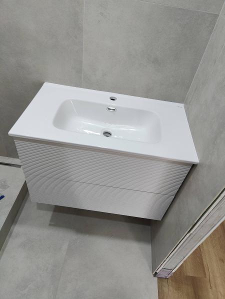 Установлена новая раковина, подключены водопроводные трубы, герметизация швов, проверка на утечки, монтаж смесителя, выравнивание конструкции, завершение отделки.