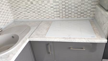 На кухне установлена столешница из ДСП, выполнены вырезы для мойки и варочной панели, закреплены плинтусы для защиты от влаги, обеспечена плотная стыковка с мебелью.