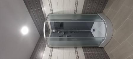 Установлена современная душевая кабина с полукруглыми стеклянными дверями. Проведены сантехнические работы, обновлена плитка на стенах и полу, обеспечена герметичность соединений.