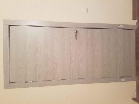 Установлен запорный механизм в деревянное полотно, выполнено аккуратное сверление, закреплена ручка, проверена функциональность, обеспечена надежная фиксация, завершены отделочные работы.
