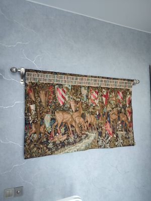 На стене закреплён гобелен на металлическом карнизе. Установлены крепления, произведён монтаж декоративного элемента. Стена выровнена, устранены дефекты поверхности.