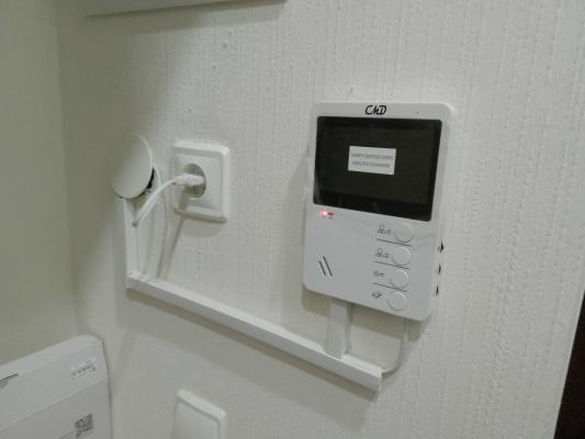 Установлено устройство связи на стене, подключены провода, закреплены элементы. Техника протестирована, готова к эксплуатации. Завершена настройка для использования.