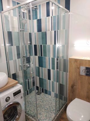 Установлена стеклянная конструкция с низким основанием, подключены водопроводные элементы, закреплены дверцы, герметично обработаны швы, проверена функциональность системы.