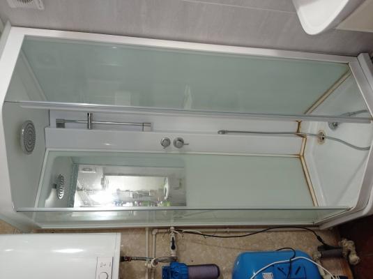 Установлена новая кабина: закреплены стенки, поддон, двери, подключены водопроводные шланги, герметизация швов, проверка работы смесителя и душа, завершение монтажа.