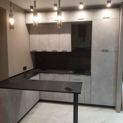 Установлена новая столешница из искусственного камня, точно подогнанная по размерам, с аккуратными швами и вырезами для техники, обеспечивающая современный и стильный вид кухни.