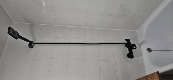 Установлено новое оборудование: закреплен черный душевой комплект, подключены все необходимые коммуникации, проверена герметичность соединений, обеспечена функциональность системы.