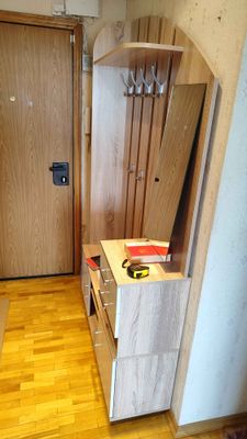 Собран шкаф с полками, ящиками и зеркалом. Установлены крючки для одежды. Все элементы надежно закреплены, обеспечивая функциональность и эстетичный вид.