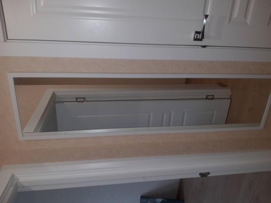 Изображение показывает завершённую работу: ковер надежно закреплен на стене, создавая уютную атмосферу в интерьере. Стены и пол гармонично сочетаются с текстильным элементом.