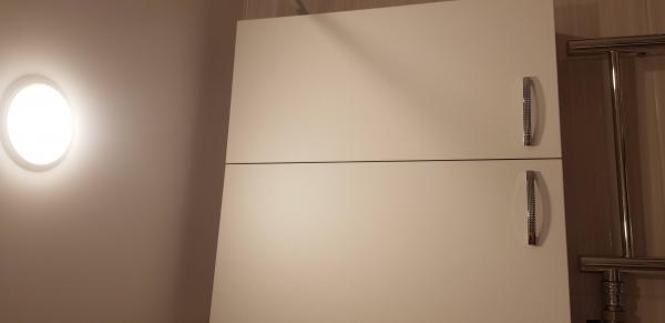 Собран шкаф с двумя дверцами, установлены ручки, закреплены петли, выровнены панели. Работа выполнена аккуратно, конструкция устойчива, все элементы надежно зафиксированы.