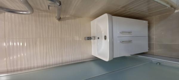 Установлена душевая конструкция, закреплены стенки, герметично обработаны швы, подключены коммуникации, проверена работа смесителя, установлена раковина с тумбой, завершены отделочные работы.