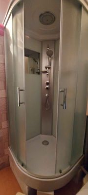 Установлена современная душевая конструкция с низким основанием. Смонтированы стеклянные панели, закреплены дверцы, подключены водопроводные коммуникации, проверена герметичность соединений.
